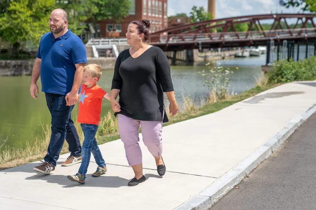 Jen Lunsford walking outdoors with her husband and son by the river